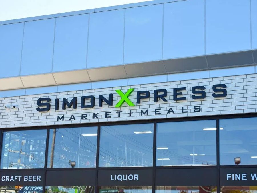 Simon Xpress Market and Meals letters on a white storefront