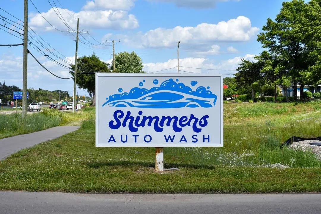 Shimmers Auto Wash monument sign on a grass strip beside a road