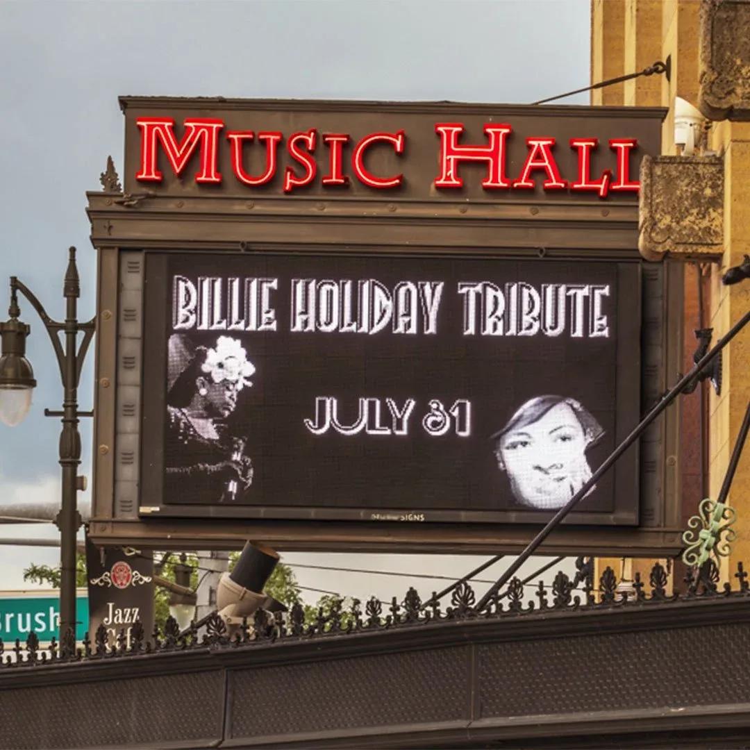 Music Hall marquee with red letters above an electronic message center showing an event
