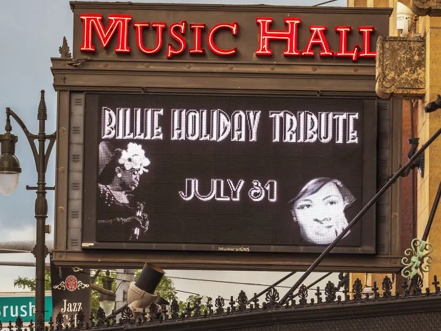 Music Hall marquee with red letters above an electronic message center showing an event
