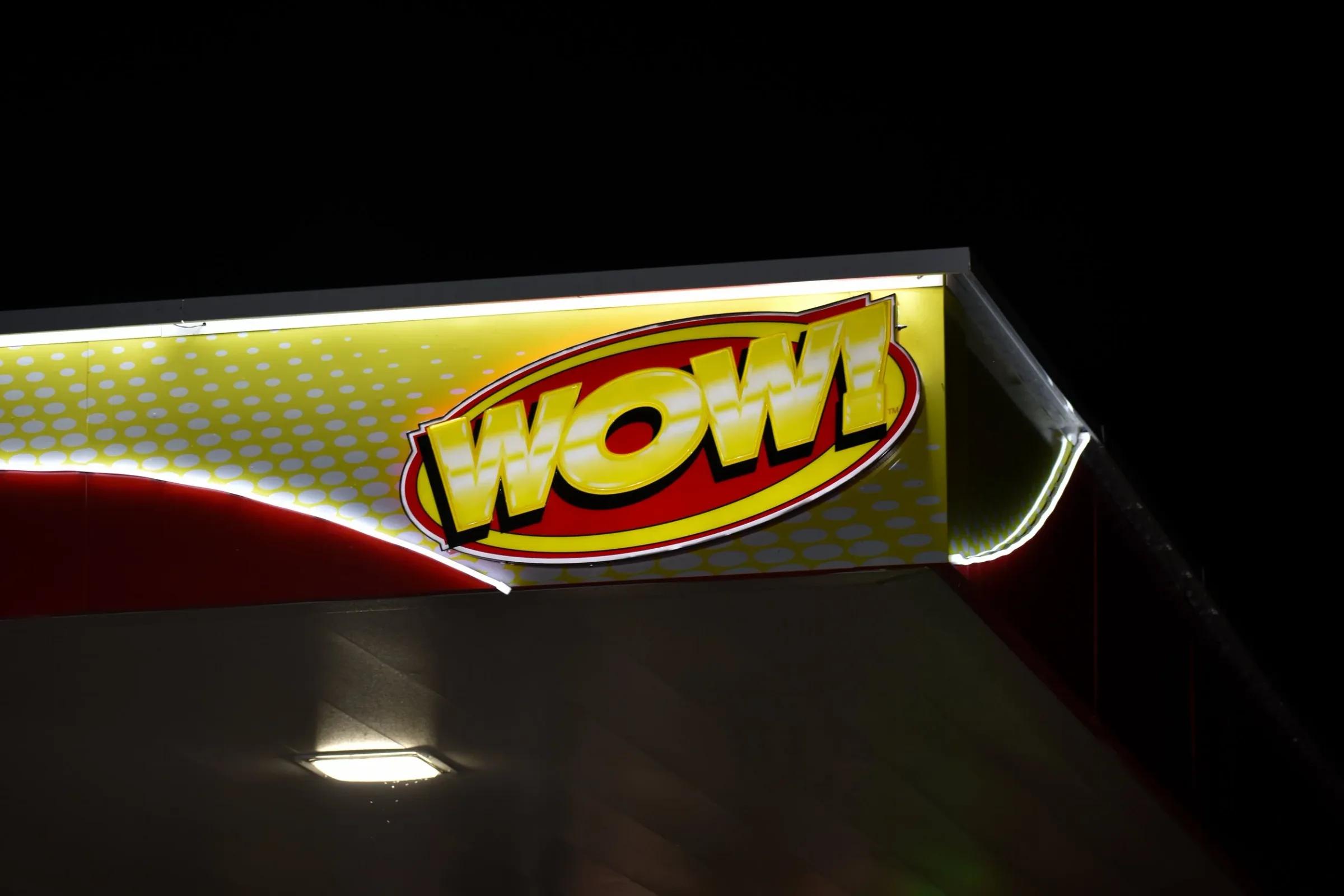 WOW logo on an illuminated canopy fascia at night