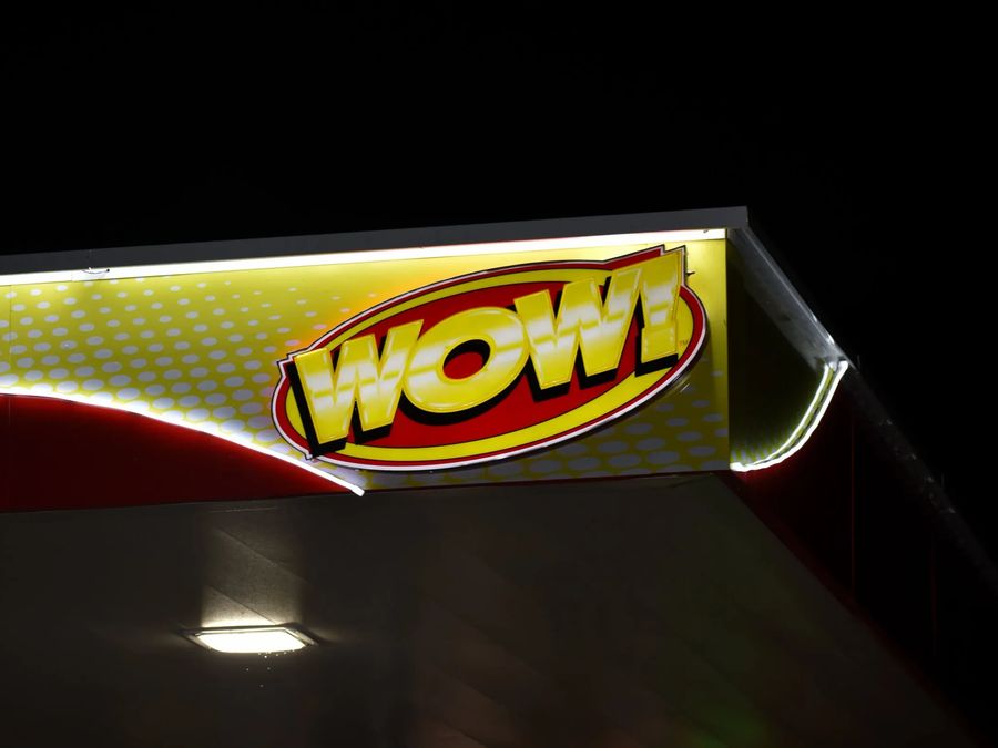 WOW logo on an illuminated canopy fascia at night