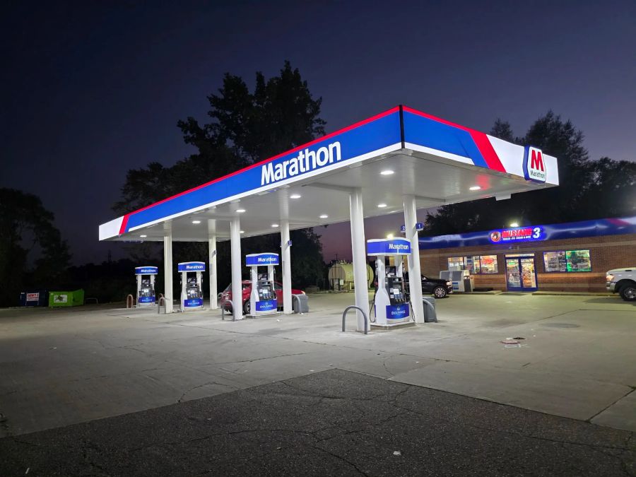Marathon canopy with its blue and red fascia lit at night over branded dispensers