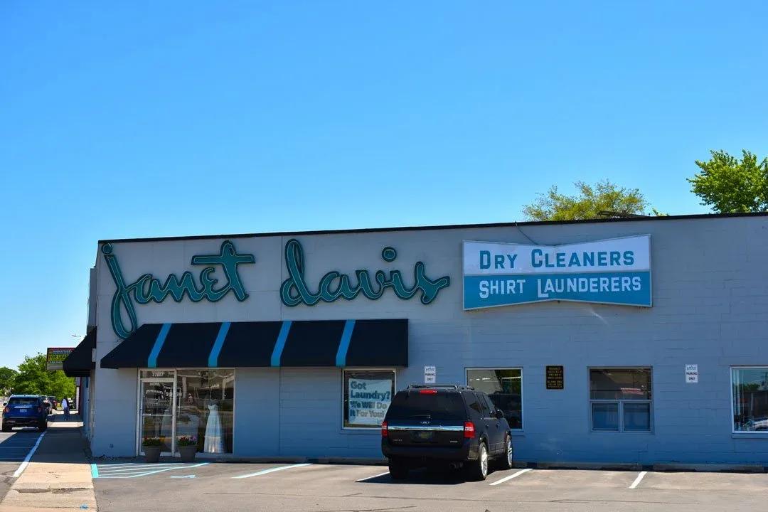 Janet Davis script letters and a Dry Cleaners panel on a white building