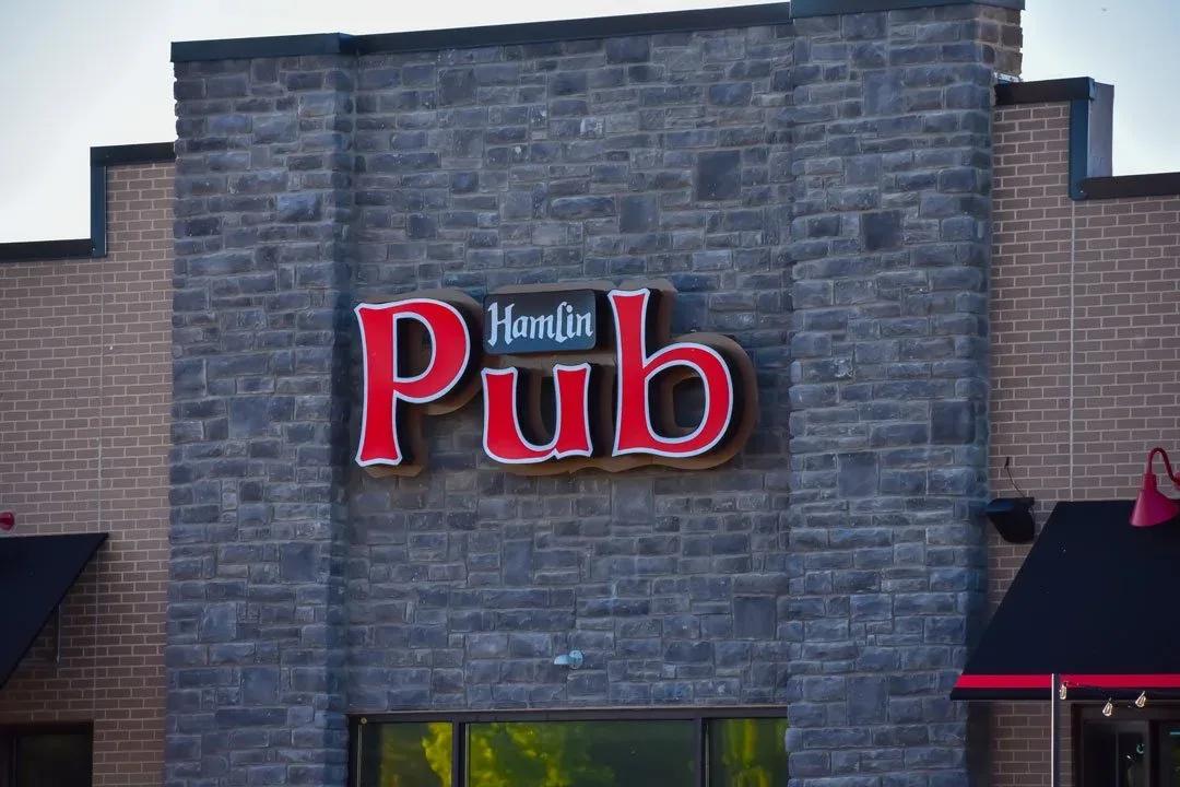 Red Hamlin Pub channel letters on a stone building front