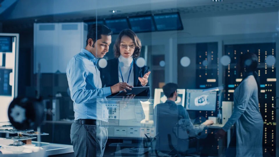 AI engineers reviewing data on a tablet in a technology lab
