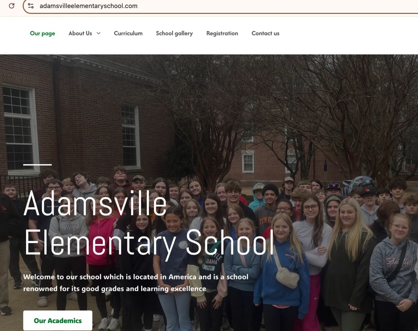 Fake Adamsville Elementary School site at adamsvilleelementaryschool.com, copying the school’s name over a student group photo to look legitimate