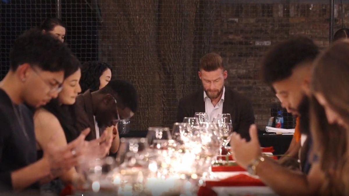 XVI guests bowing in prayer at the dinner table