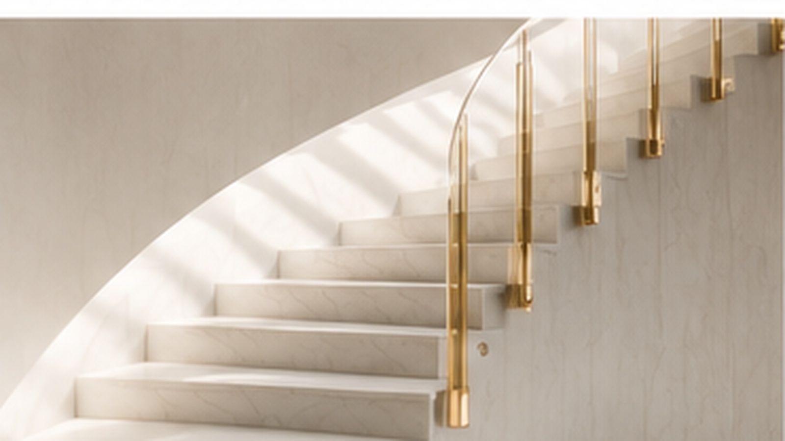 A white spiral staircase with a polished brass balustrade rising through light.