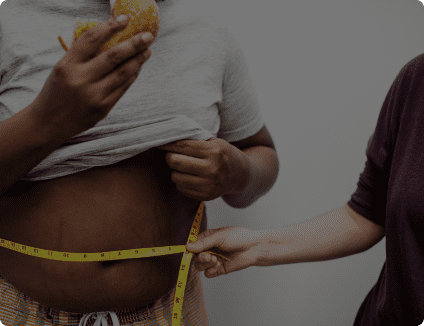 an obese child eating and checking his weight 