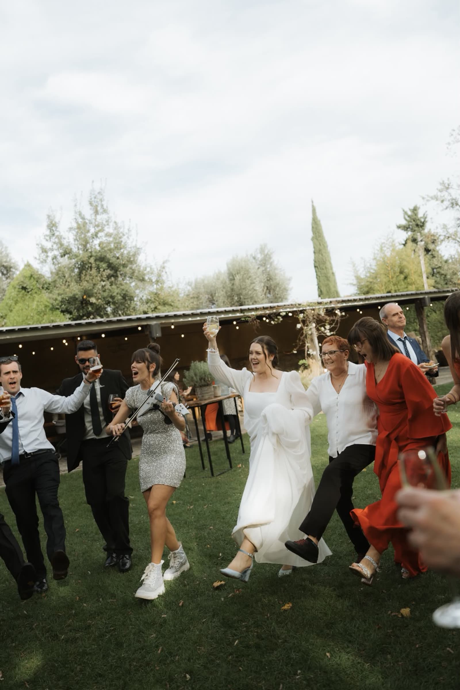 Los novios bailando junto a Astrid Torrente y sus invitados en el jardín de una boda