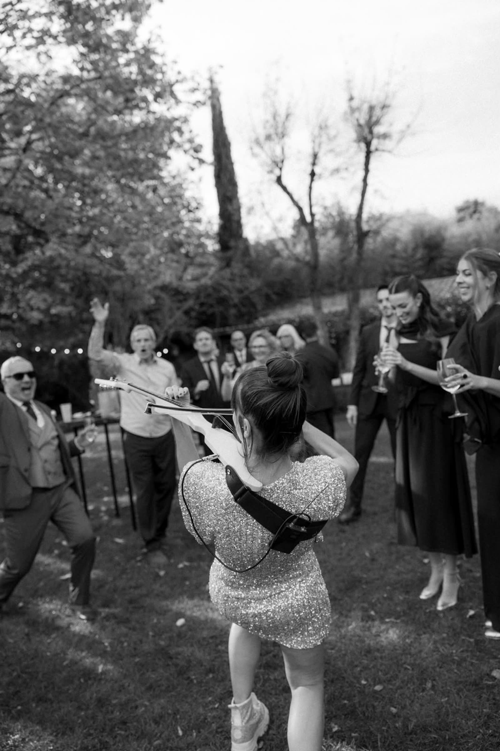Astrid Torrente tocando el violín eléctrico durante el cóctel de una boda, en blanco y negro