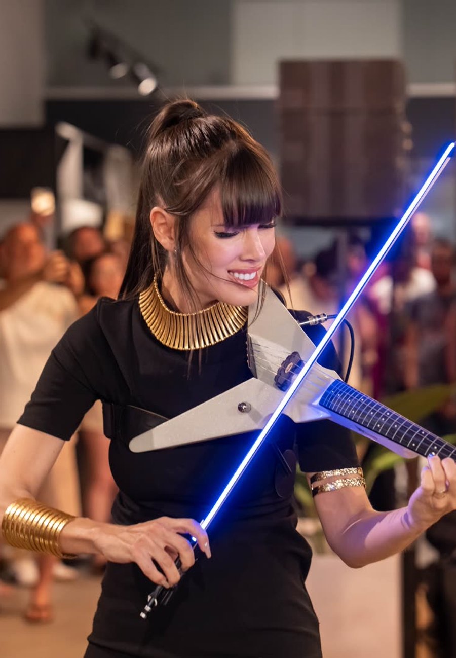 Astrid Torrente actuando con violín LED ante el público de un evento corporativo