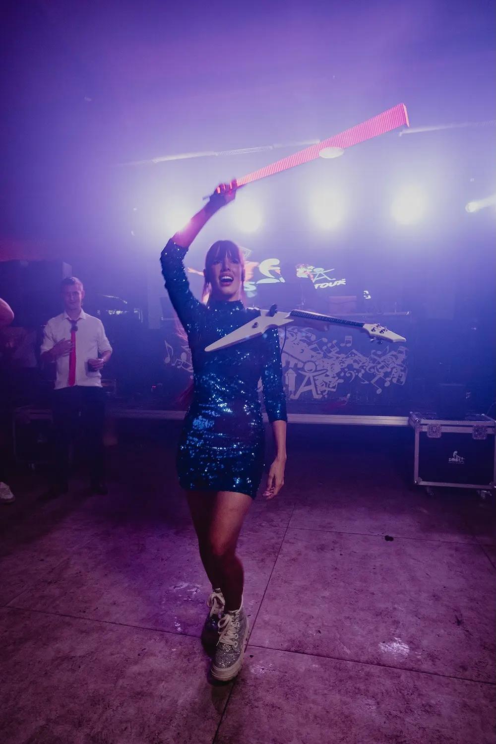 Astrid Torrente bailando con un accesorio luminoso durante una celebración nocturna