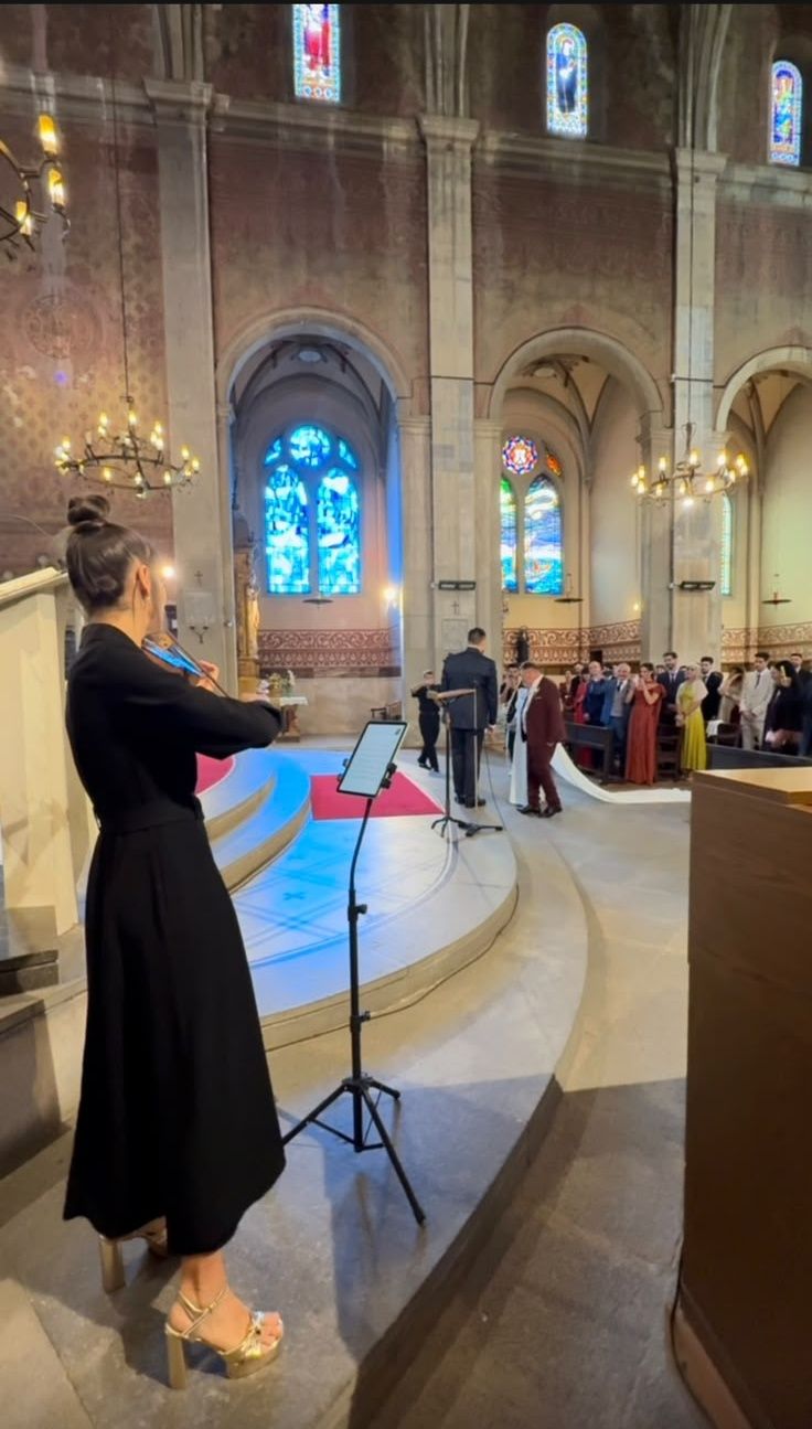 Astrid Torrente interpretando el violín durante una ceremonia de boda en una iglesia