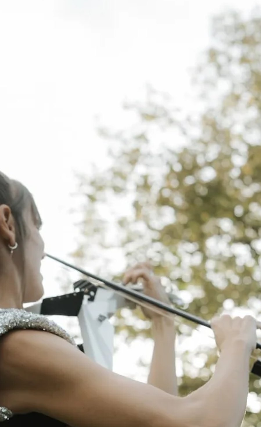 Astrid Torrente playing the electric violin during an outdoor wedding ceremony