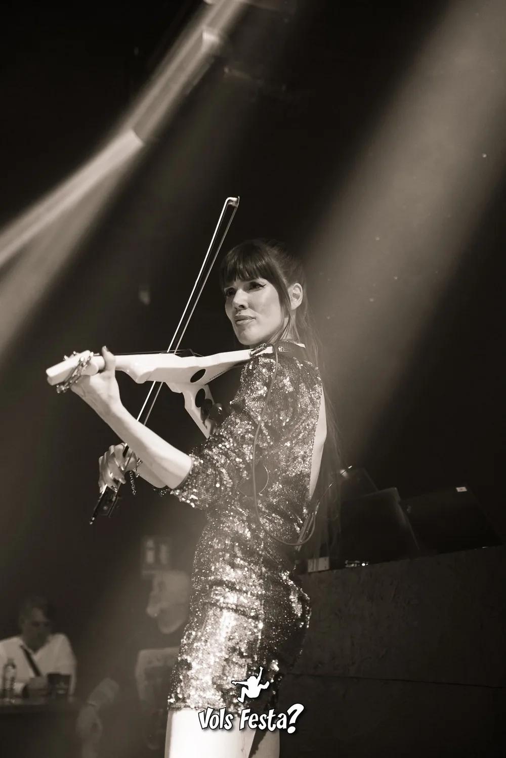 Astrid Torrente tocando el violín eléctrico en un concierto nocturno