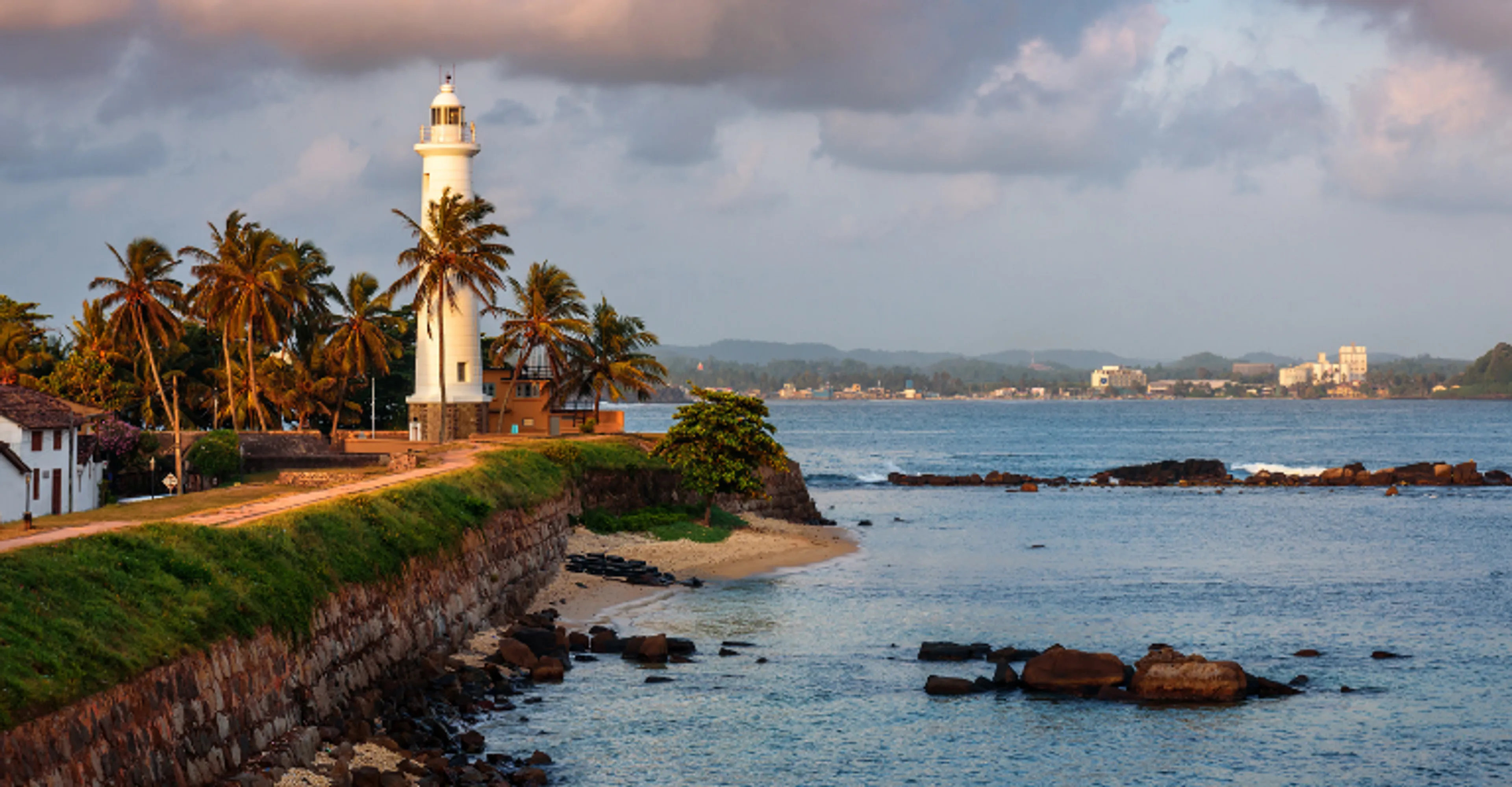 The lighthouse and coastal rampart of Galle Fort at sunset