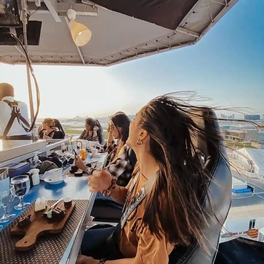 Dining table suspended in the air with guests enjoying dinner above Dubai skyline