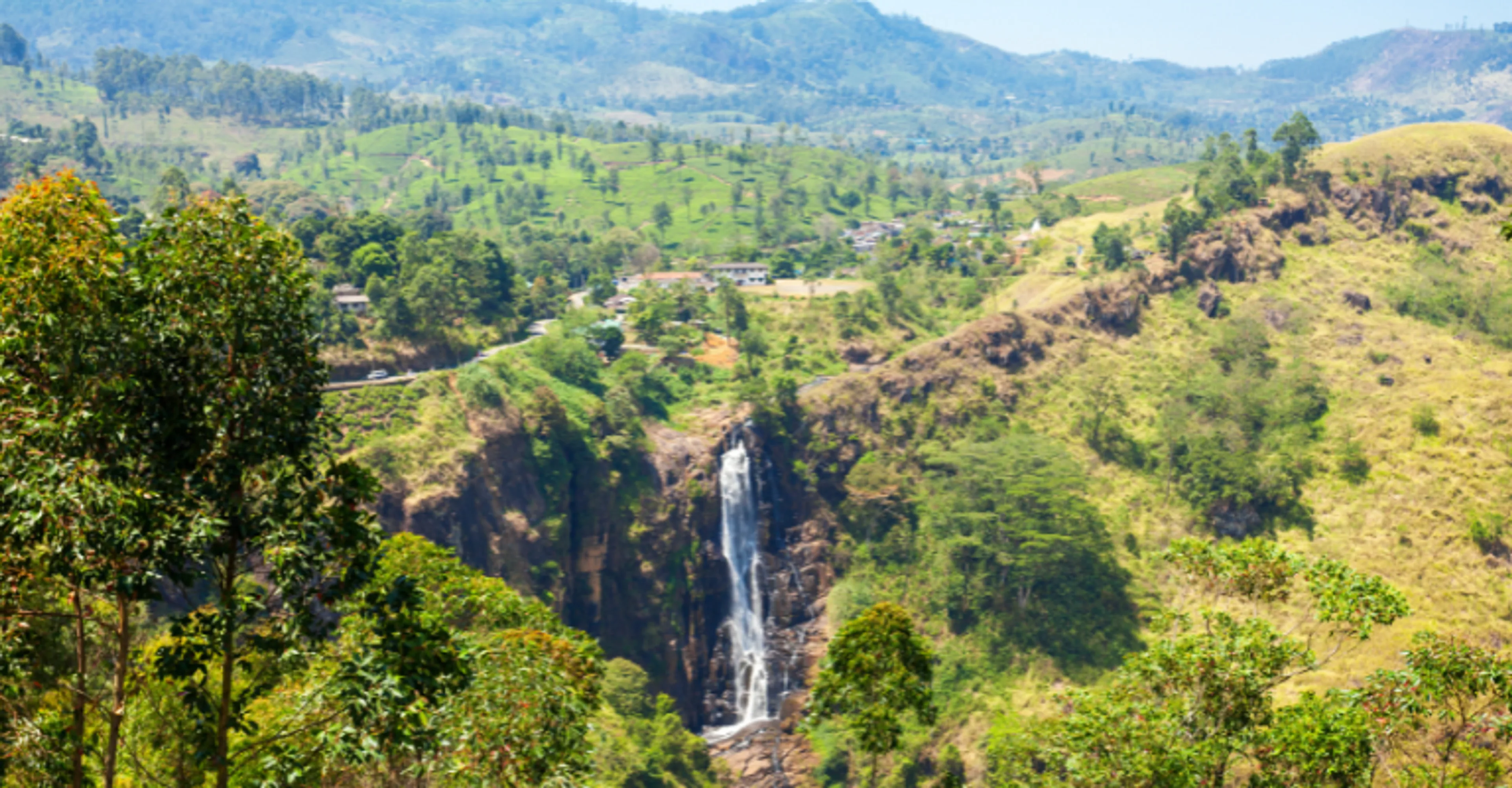 A waterfall cutting through the tea-covered hills near Nuwara Eliya