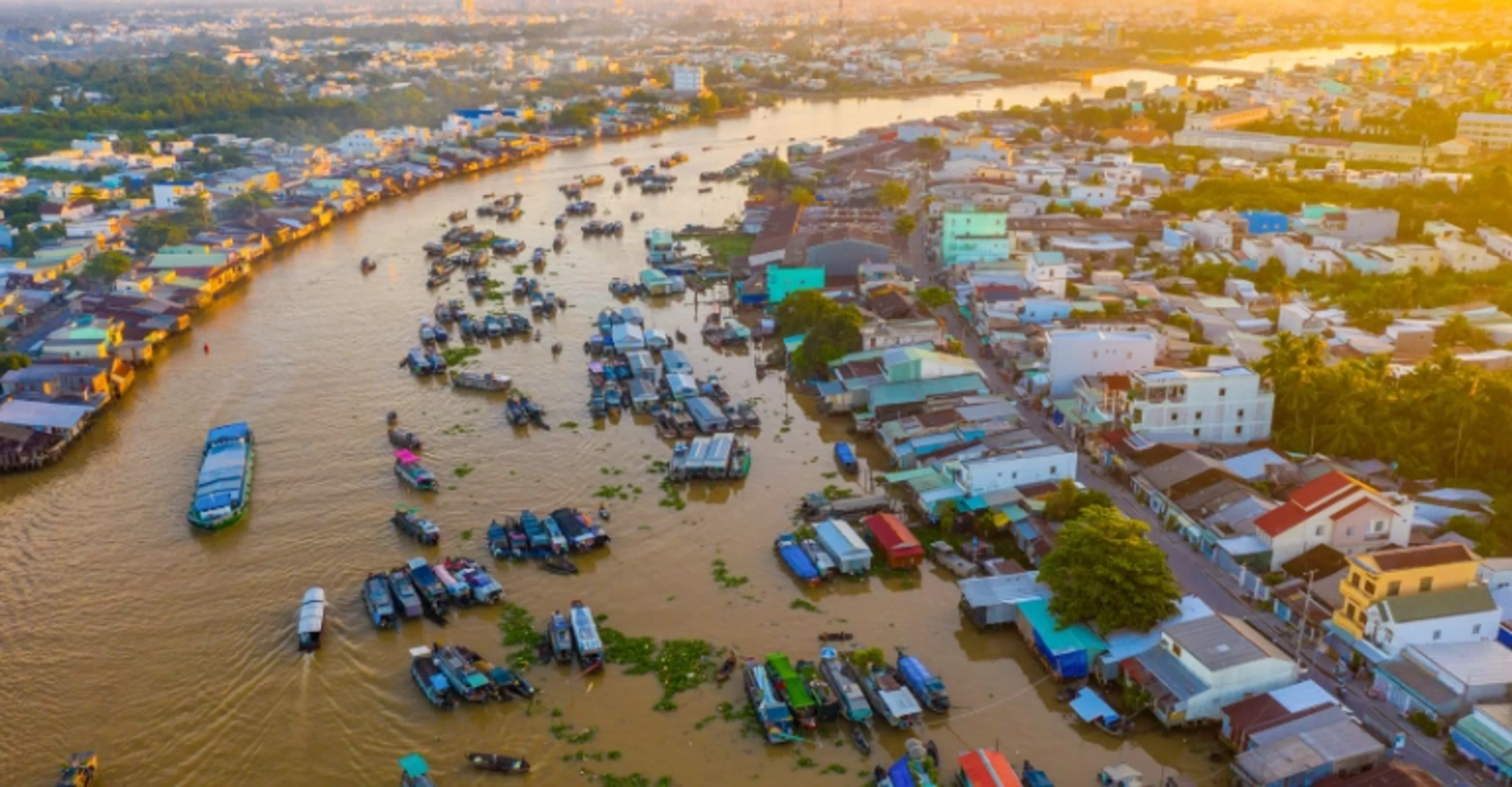 Aerial view of boats and floating markets along a river in the Mekong Delta