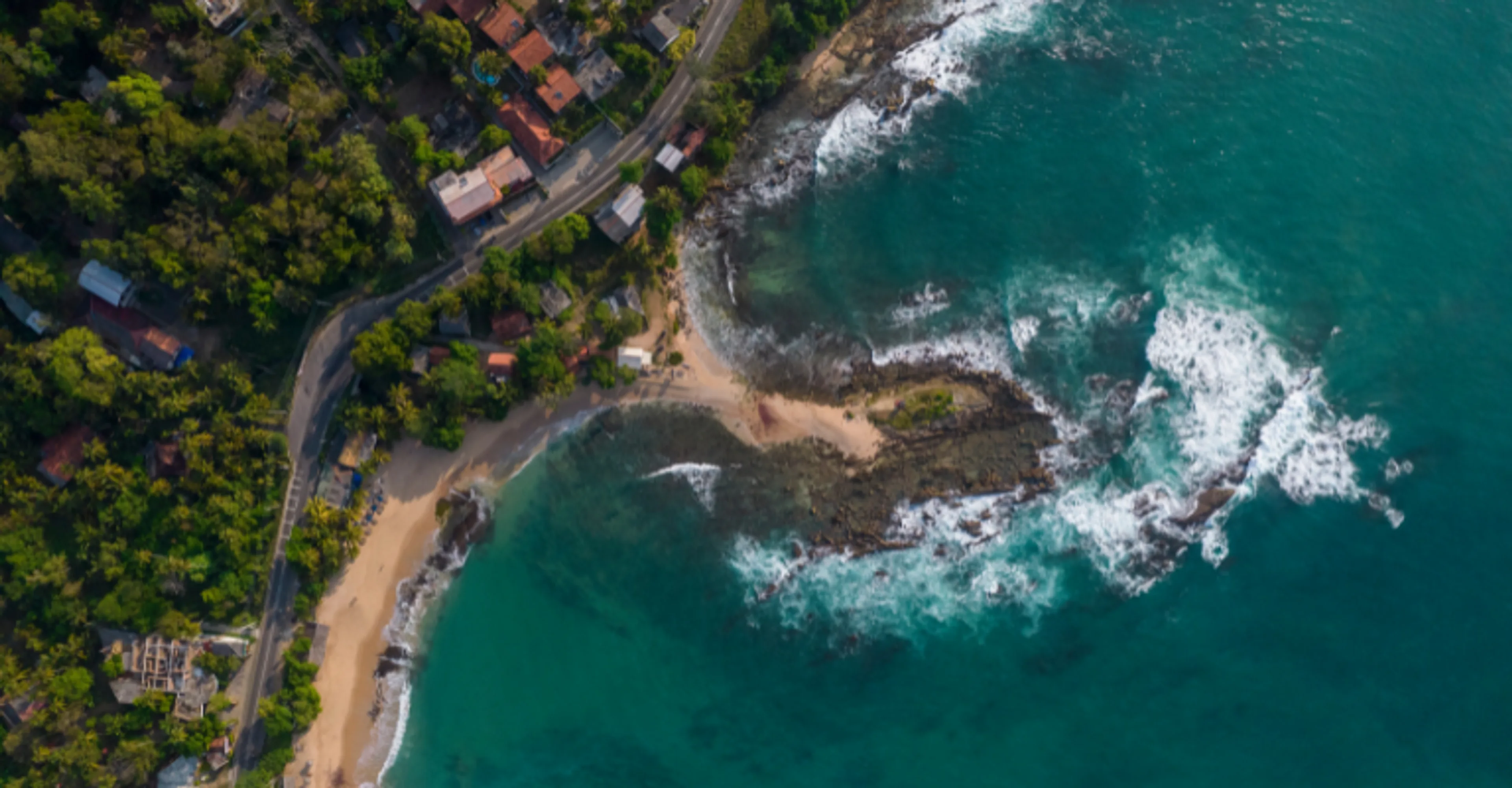 Aerial view of a rocky cove and coastal road along Sri Lanka's south coast