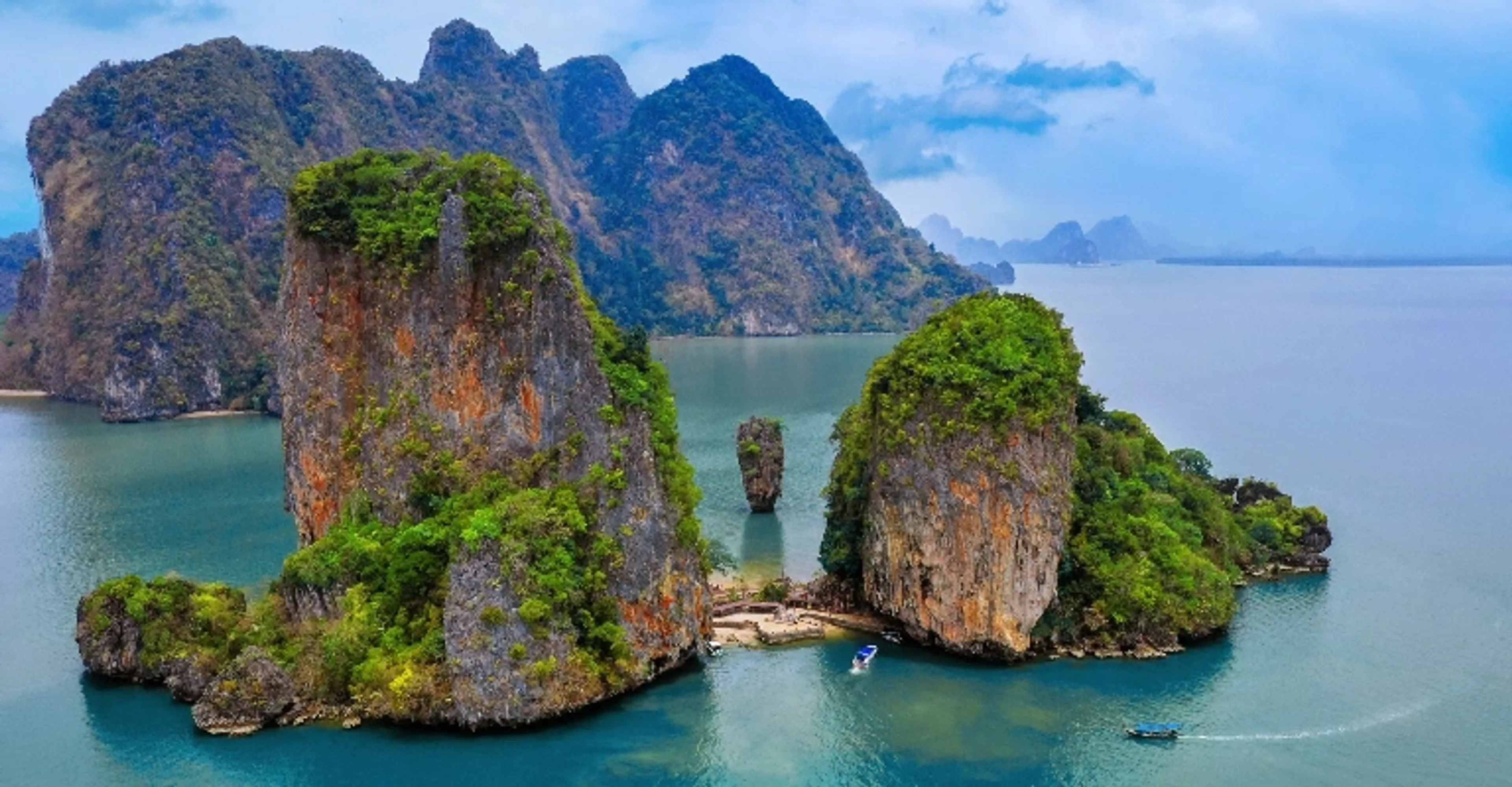 A longtail boat over turquoise water near a Thai island