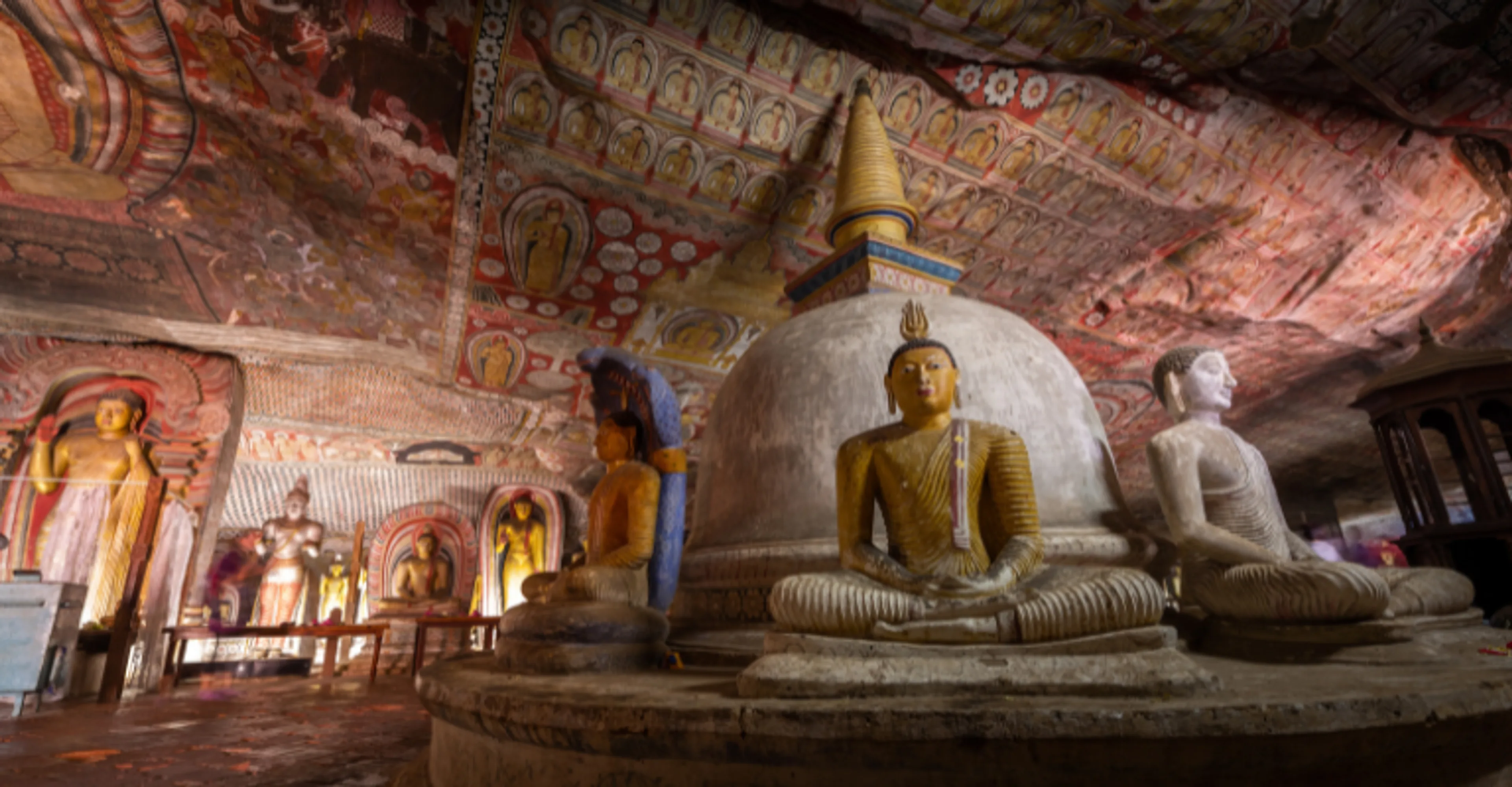 Golden Buddha statues and painted ceilings inside the Dambulla Cave Temple