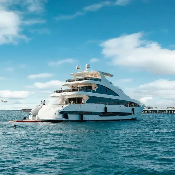 Luxury yacht cruising along Dubai coastline with skyline in the background