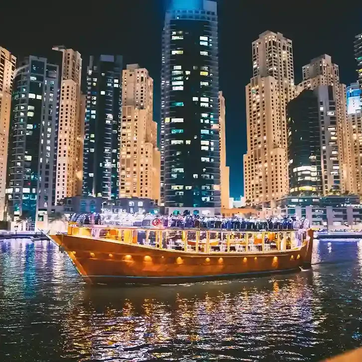 Traditional dhow cruise in Dubai Marina with illuminated skyline at night