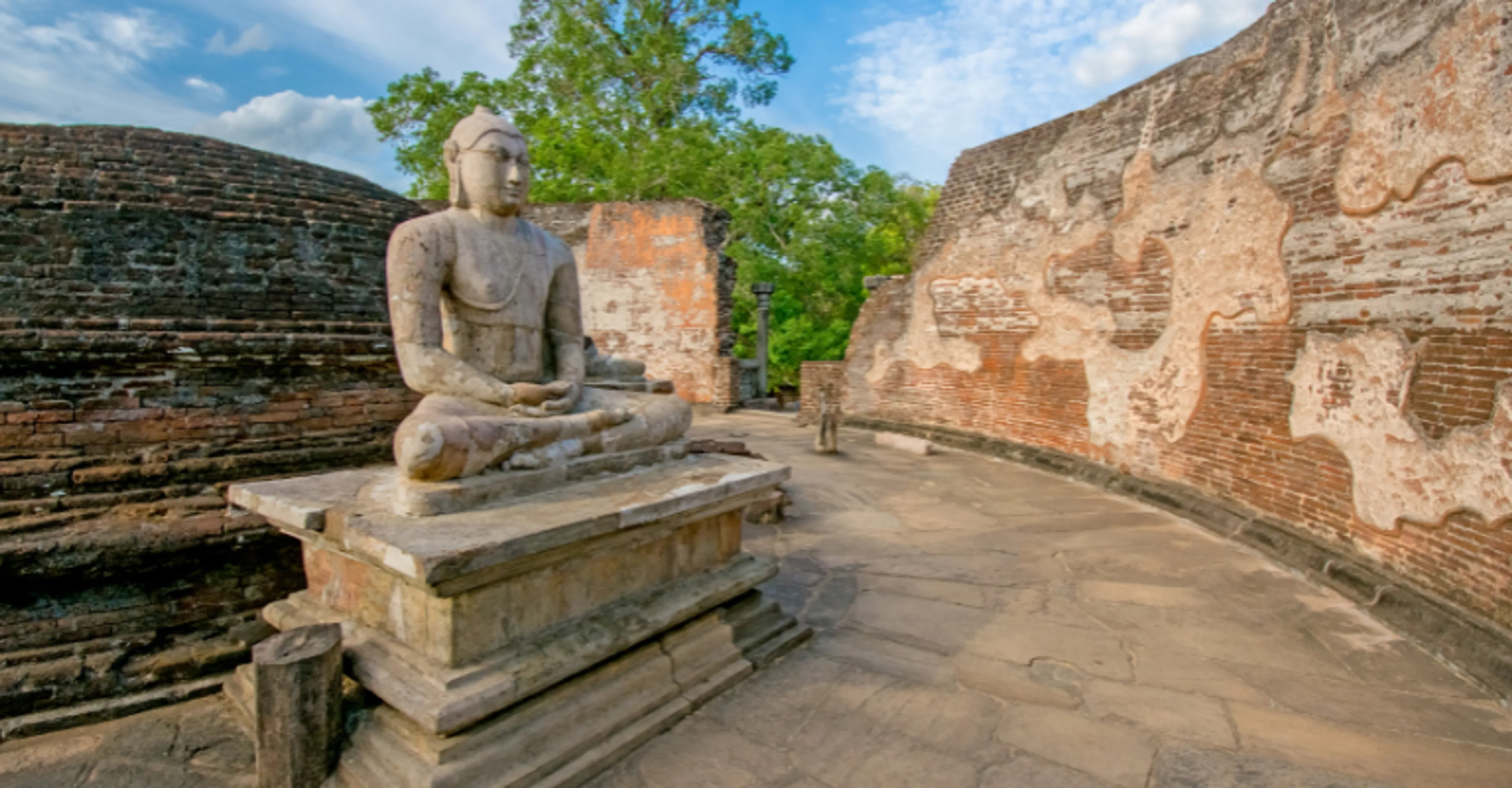 An ancient seated Buddha statue among brick ruins at Sri Lanka's ancient cities