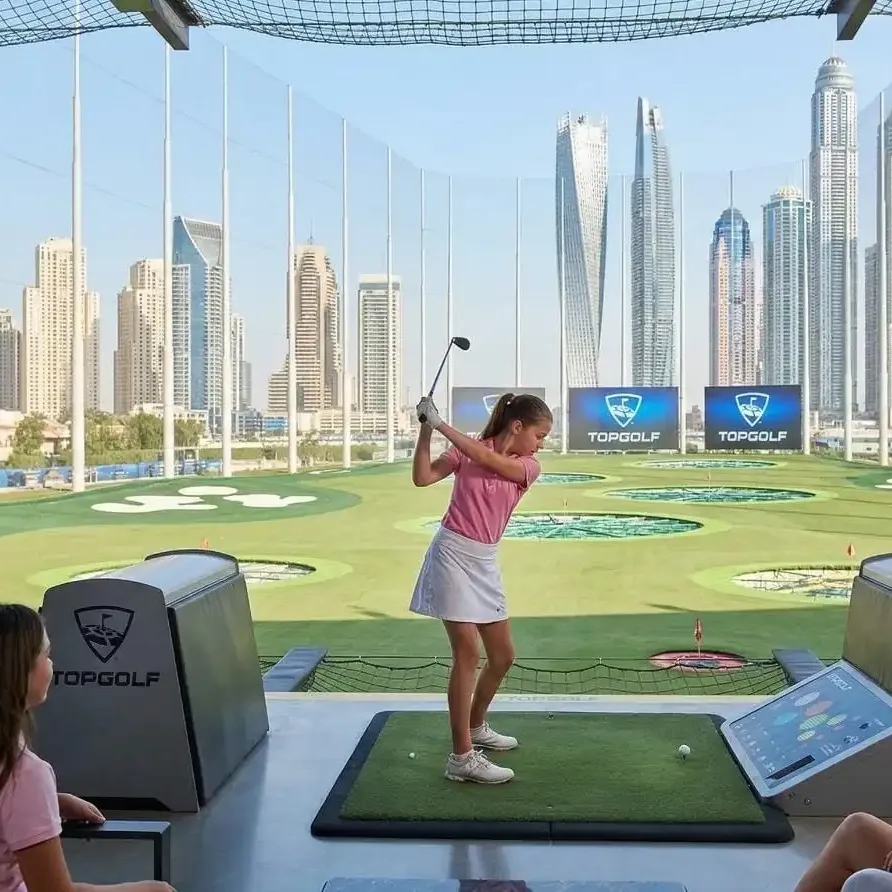 Golfers playing on premium Dubai golf course with skyline view