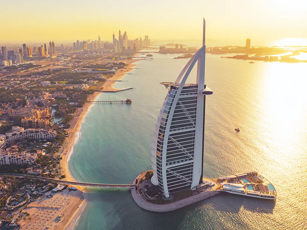 Aerial view of the Burj Al Arab and Dubai coastline at sunset