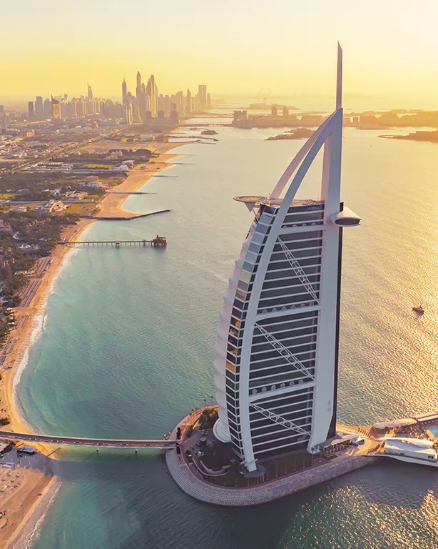 Aerial view of the Burj Al Arab and Dubai coastline at sunset