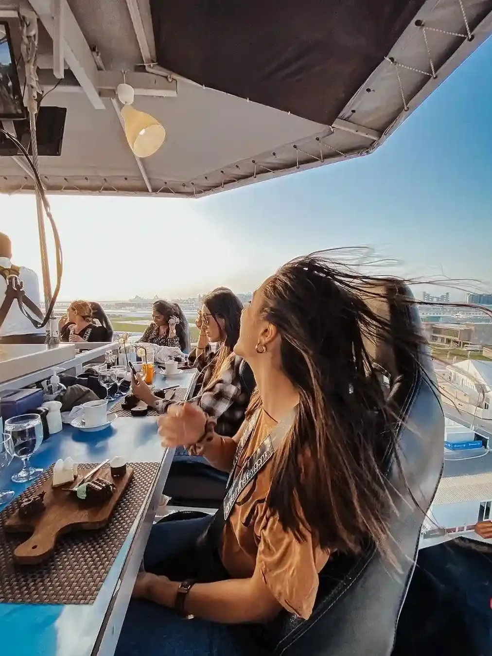 Dining table suspended in the air with guests enjoying dinner above Dubai skyline
