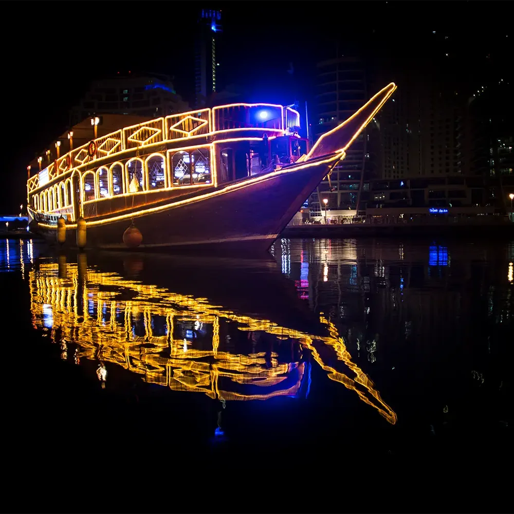 Luxury dinner cruise yacht sailing in Dubai Marina at night