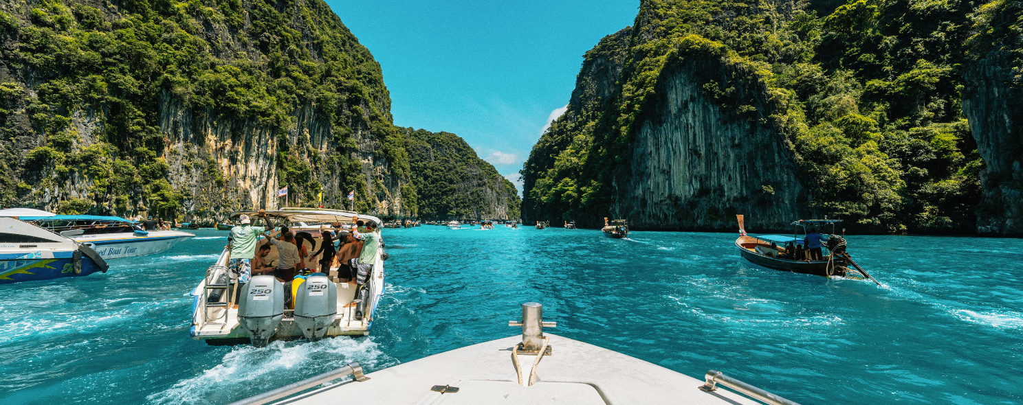 Speedboats cruising between limestone cliffs at Pileh Lagoon, Phi Phi Islands, Thailand