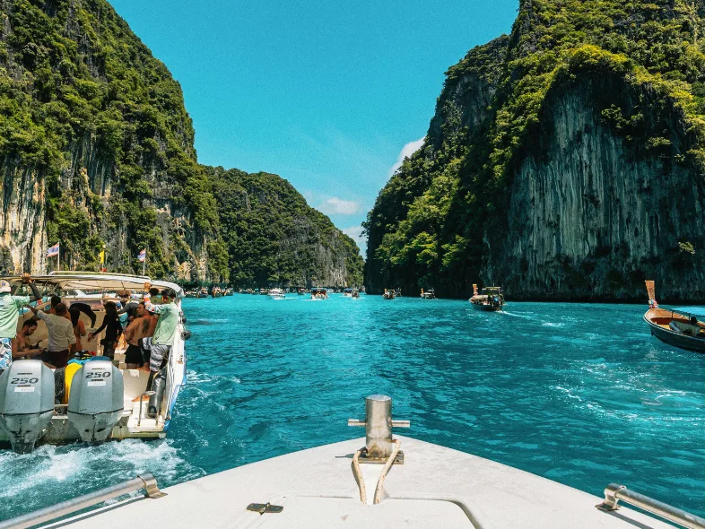 Speedboats cruising between limestone cliffs at Pileh Lagoon, Phi Phi Islands, Thailand