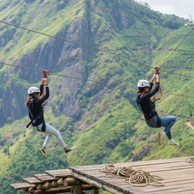Rider soaring on the Flying Ravana mega zipline over tea estates in Ella Sri Lanka
