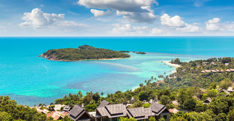 Hillside villas overlooking turquoise sea and a small island in Koh Samui, Thailand