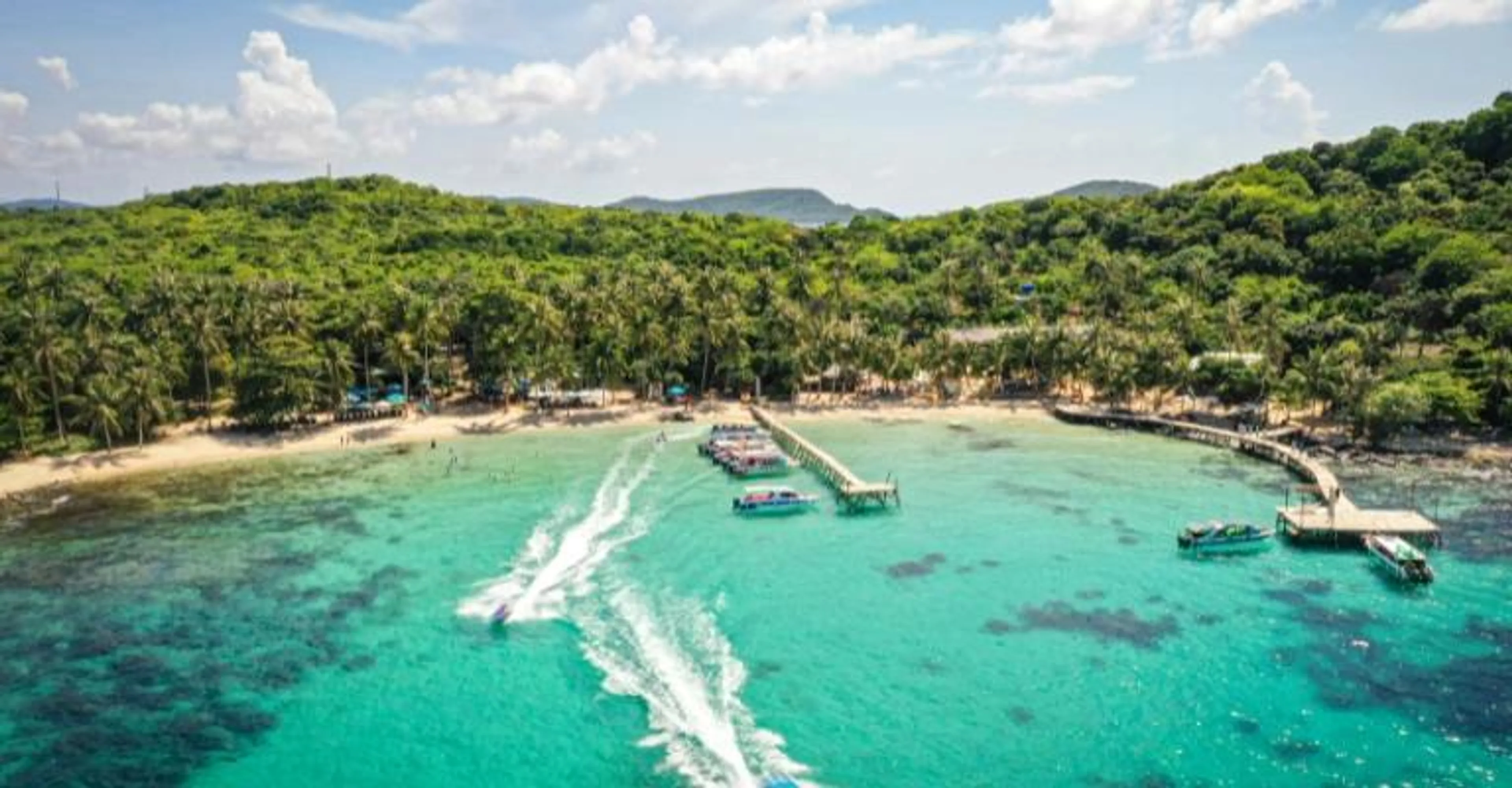Aerial view of a turquoise Phu Quoc beach with jet skis and moored boats