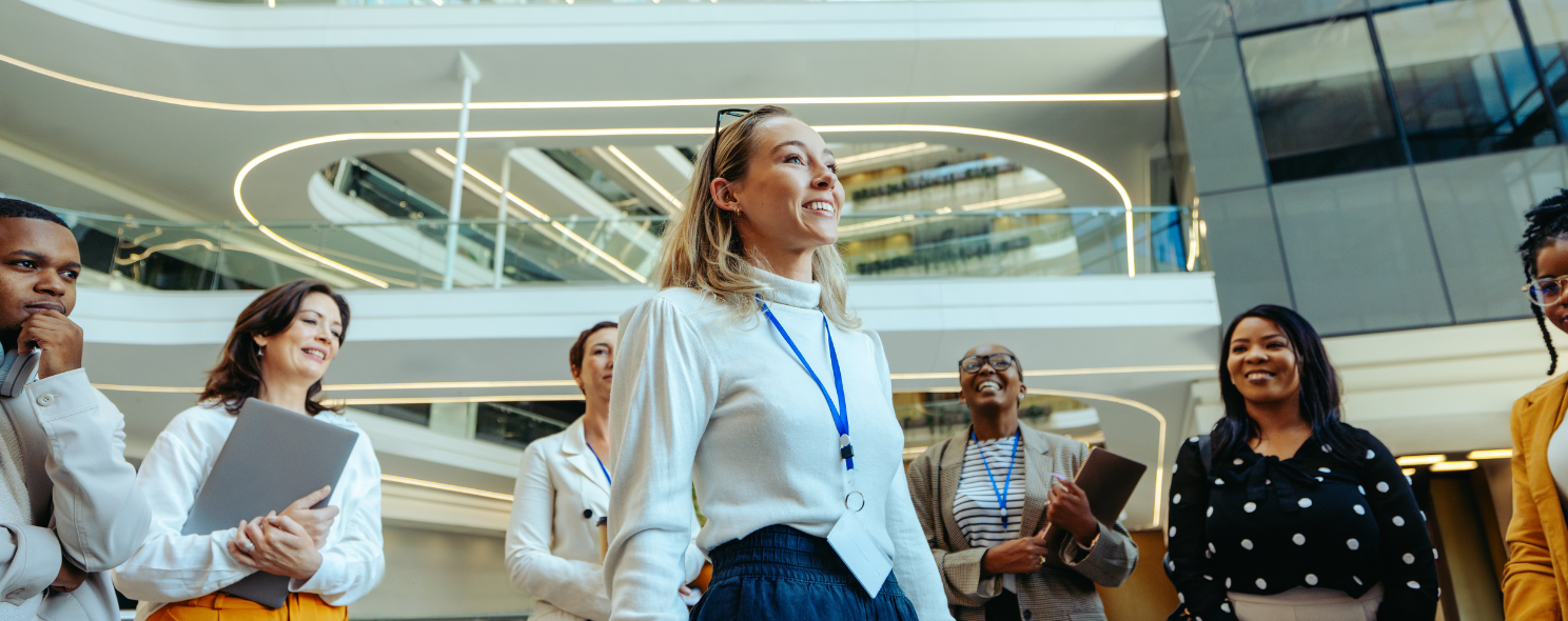 Group of smiling business professionals gathered in a modern office lobby