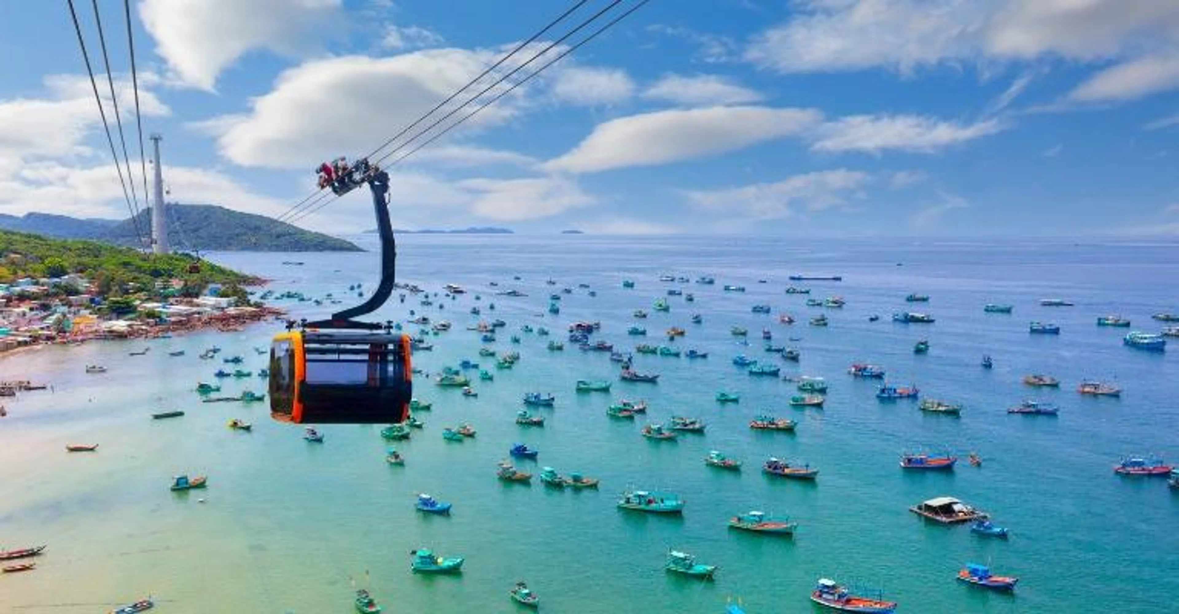 Phu Quoc cable car crossing the sea above a harbor of fishing boats