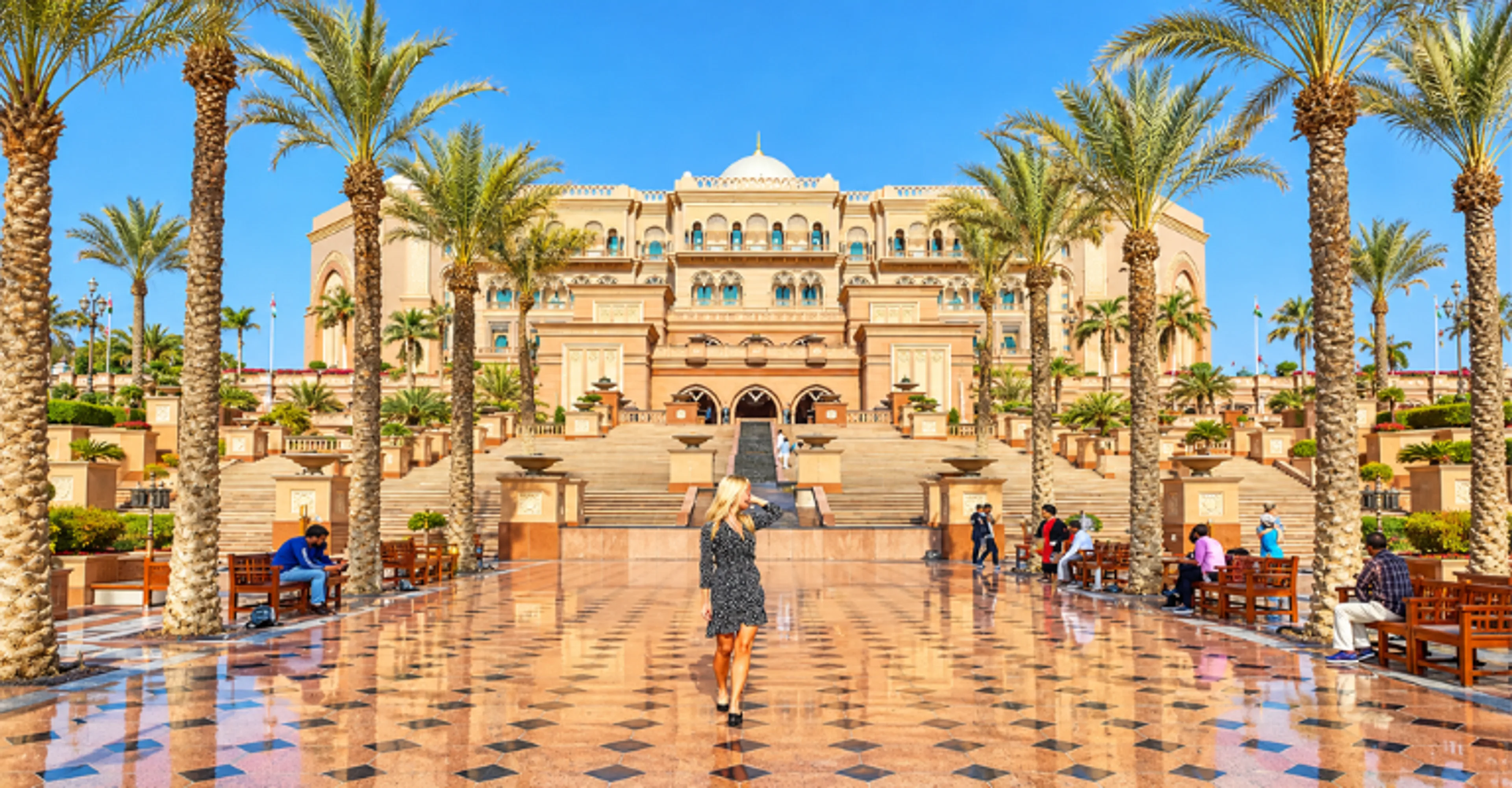 Woman walking toward Emirates Palace in Abu Dhabi