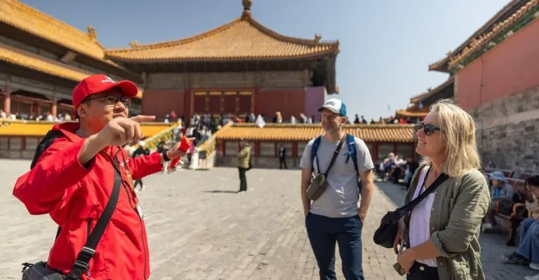Licensed China DMC tour guide explaining Forbidden City history to international travelers in Beijing