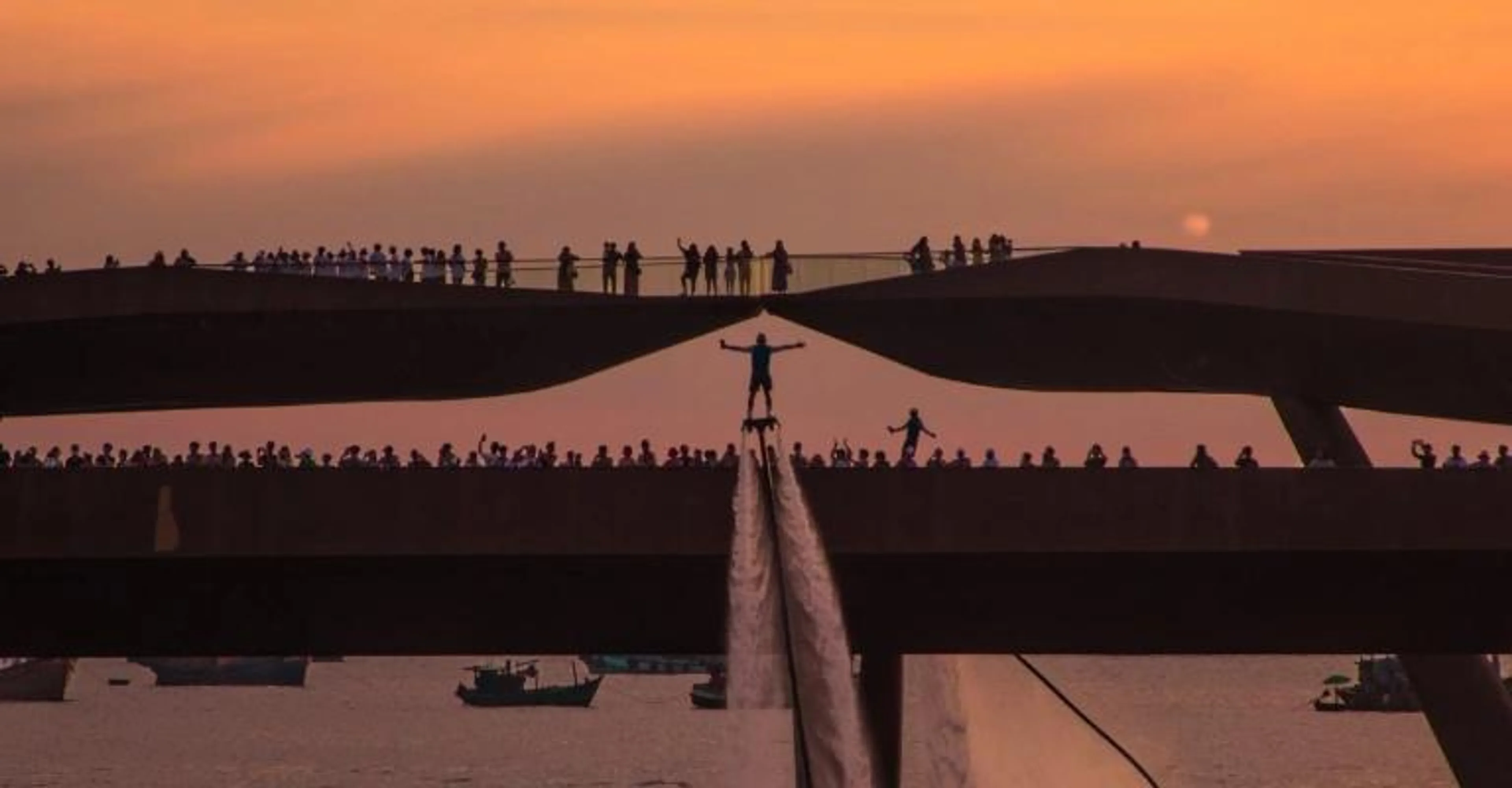 Silhouettes of visitors on Kiss Bridge at sunset over Phu Quoc