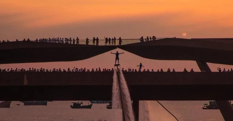 Silhouettes of visitors on Kiss Bridge at sunset over Phu Quoc