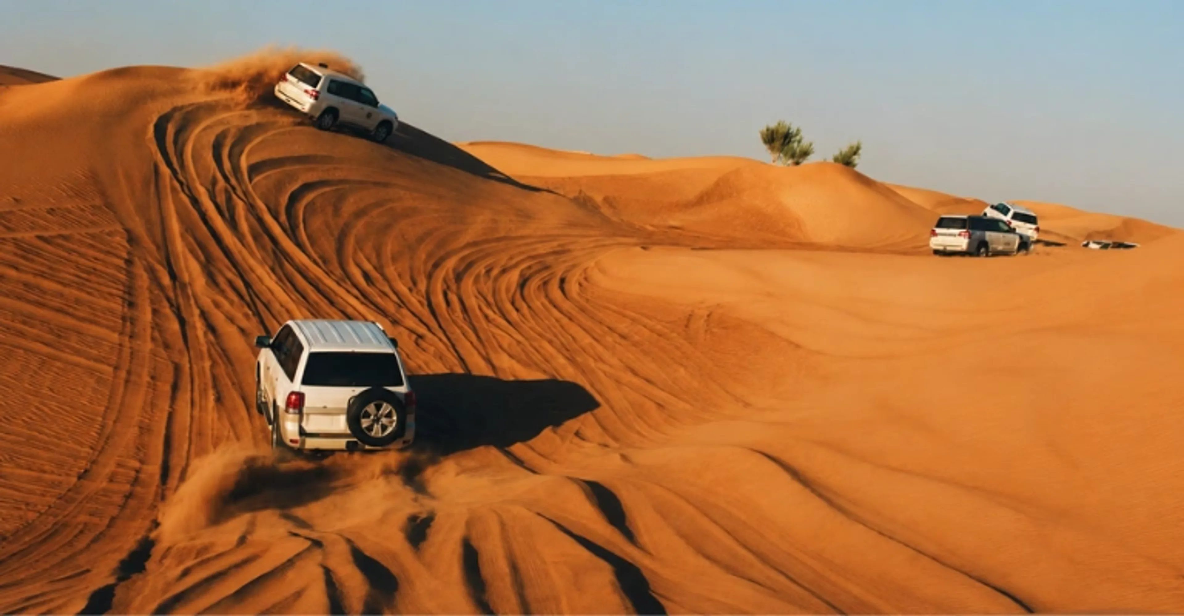 4x4 vehicles driving across sand dunes during a Dubai desert safari