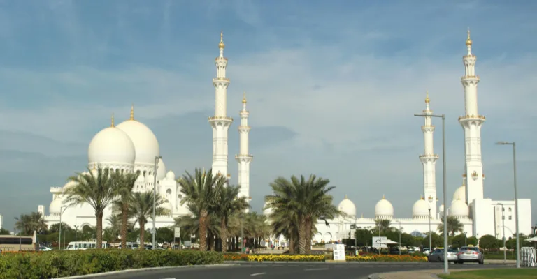 Sheikh Zayed Grand Mosque with palm trees seen from the road, Abu Dhabi