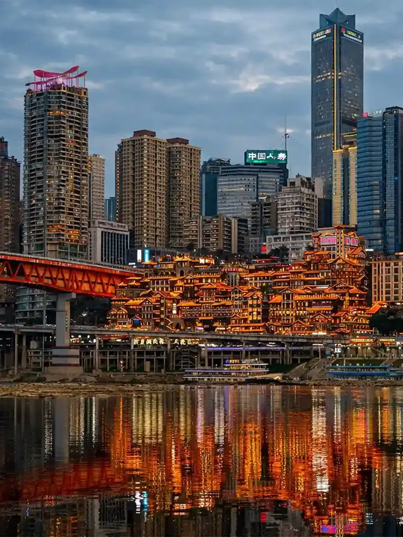 Hongya Cave Chongqing illuminated at night with traditional stilt buildings along the riverfront